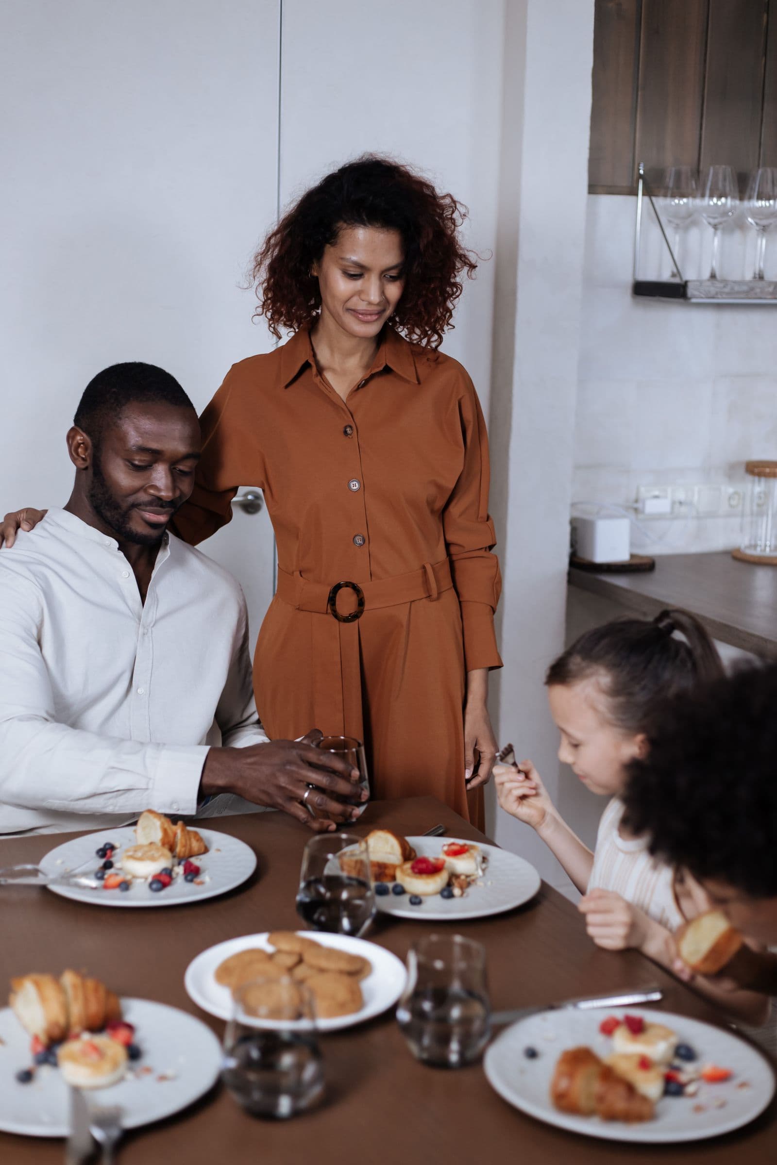 Parents and children gathered around a table for breakfast